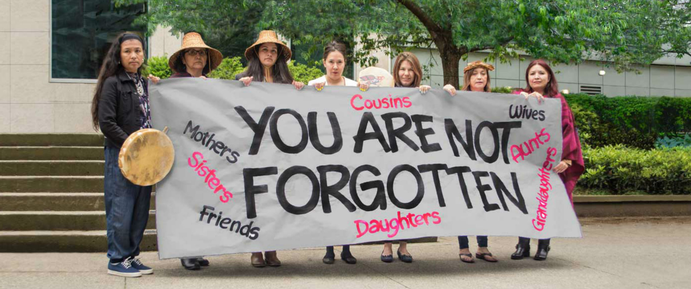 Women holding a sign that says You are not forgotten