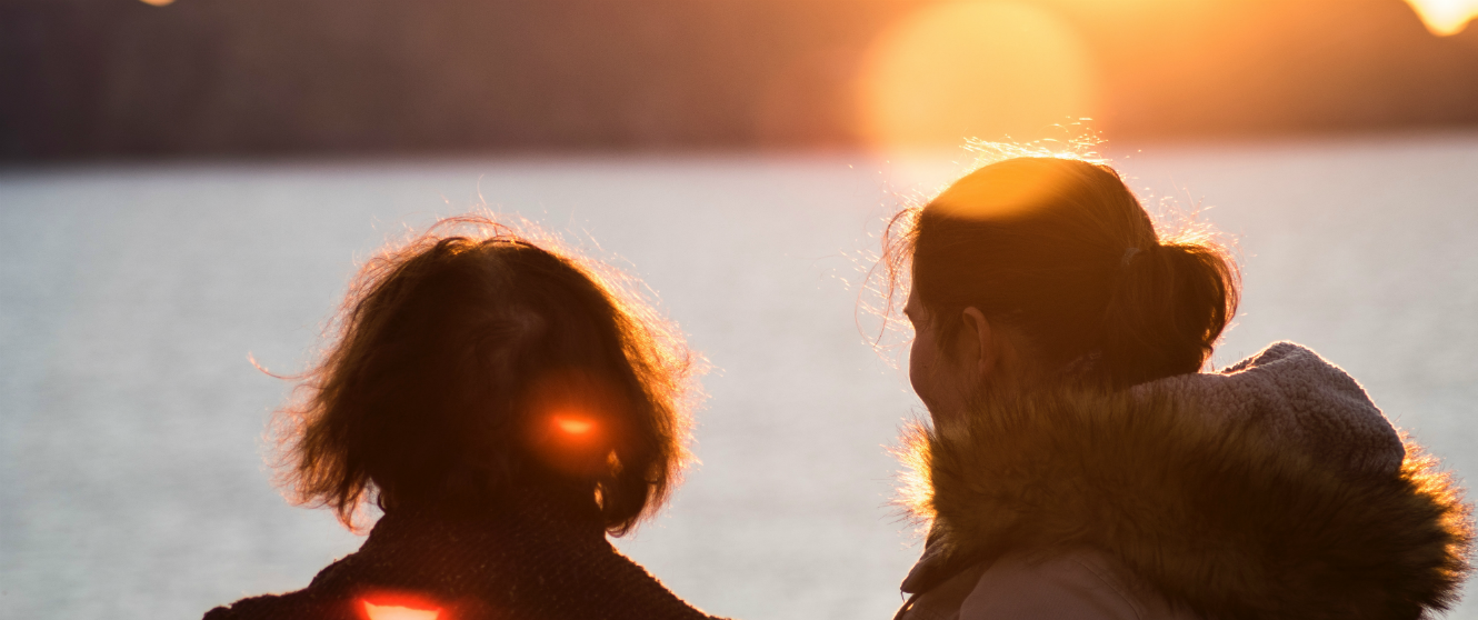 Two people looking out over water.