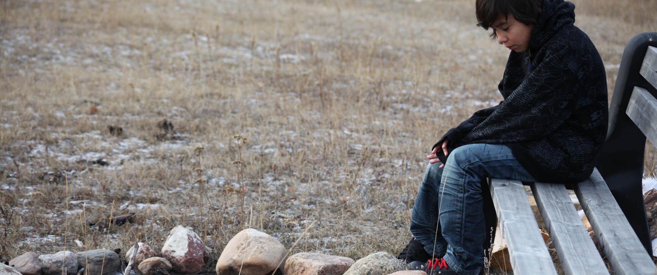 Male youth sitting on bench